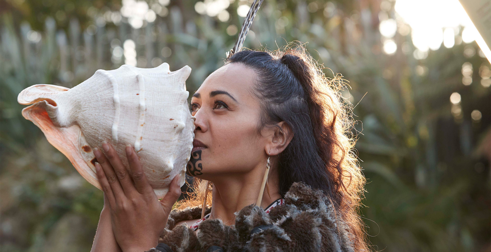 maori women blowing into shell